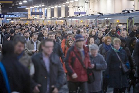 A huge crowd disembark from a train in London