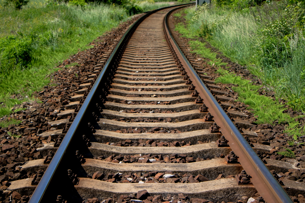 Empty Railway Tracks French railway network operator SNCF Réseau, has enhanced its vegetation management operations in response to unseasonable overgrowth, incorporating a state-of-the-art spider excavator to improve track maintenance.